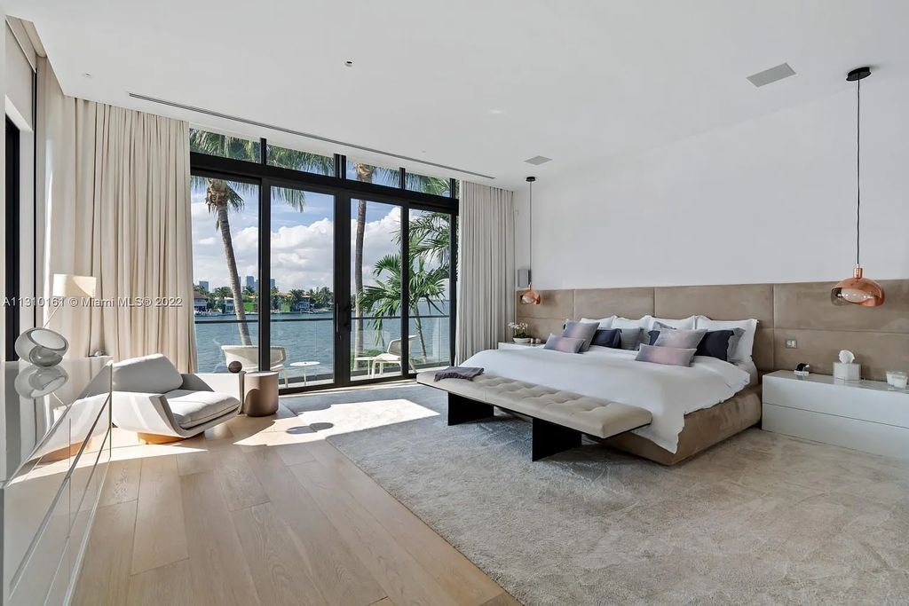 This stunning Venetian Island waterfront home located 420 W Rivo Alto Dr, Miami Beach, FL, boasts luxurious finishes. The tropical modern residence showcases a series of architectural scenes with seamless indoor-outdoor living, incorporating natural elements and offering breathtaking wide bay westerly sunsets