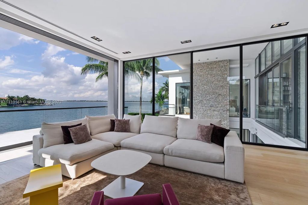 This stunning Venetian Island waterfront home located 420 W Rivo Alto Dr, Miami Beach, FL, boasts luxurious finishes. The tropical modern residence showcases a series of architectural scenes with seamless indoor-outdoor living, incorporating natural elements and offering breathtaking wide bay westerly sunsets