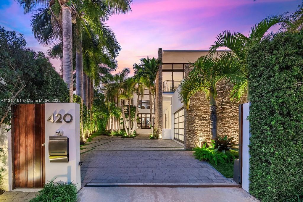 This stunning Venetian Island waterfront home located 420 W Rivo Alto Dr, Miami Beach, FL, boasts luxurious finishes. The tropical modern residence showcases a series of architectural scenes with seamless indoor-outdoor living, incorporating natural elements and offering breathtaking wide bay westerly sunsets