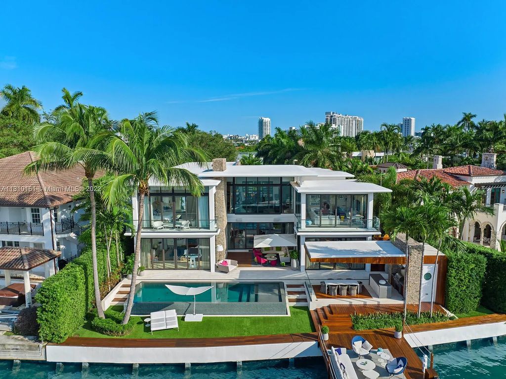 This stunning Venetian Island waterfront home located 420 W Rivo Alto Dr, Miami Beach, FL, boasts luxurious finishes. The tropical modern residence showcases a series of architectural scenes with seamless indoor-outdoor living, incorporating natural elements and offering breathtaking wide bay westerly sunsets