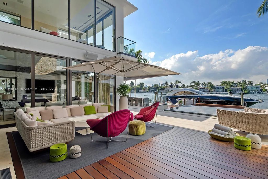 This stunning Venetian Island waterfront home located 420 W Rivo Alto Dr, Miami Beach, FL, boasts luxurious finishes. The tropical modern residence showcases a series of architectural scenes with seamless indoor-outdoor living, incorporating natural elements and offering breathtaking wide bay westerly sunsets