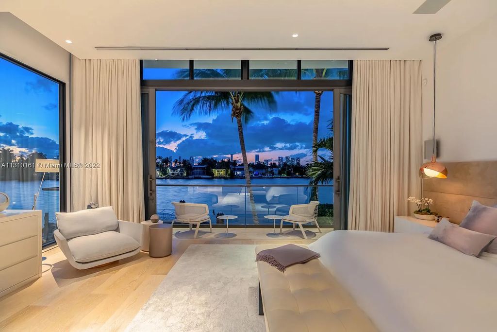 This stunning Venetian Island waterfront home located 420 W Rivo Alto Dr, Miami Beach, FL, boasts luxurious finishes. The tropical modern residence showcases a series of architectural scenes with seamless indoor-outdoor living, incorporating natural elements and offering breathtaking wide bay westerly sunsets