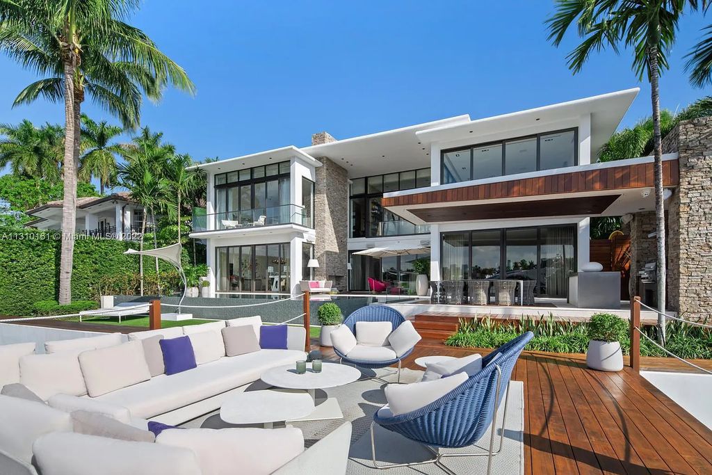 This stunning Venetian Island waterfront home located 420 W Rivo Alto Dr, Miami Beach, FL, boasts luxurious finishes. The tropical modern residence showcases a series of architectural scenes with seamless indoor-outdoor living, incorporating natural elements and offering breathtaking wide bay westerly sunsets