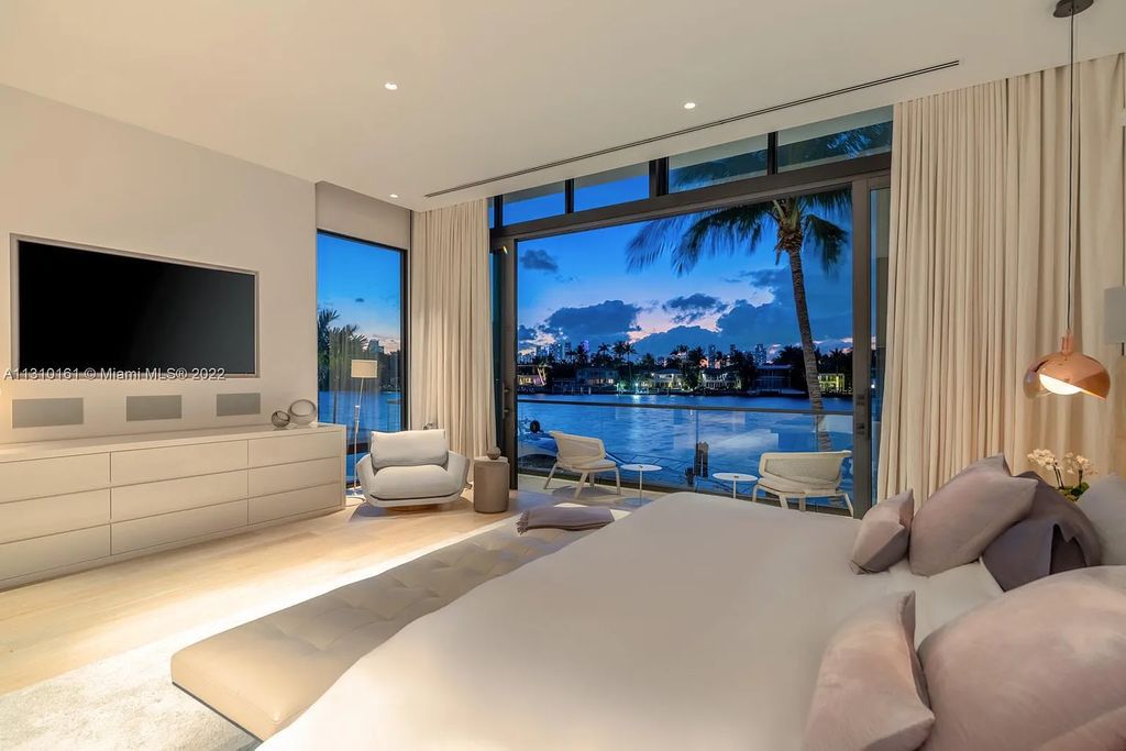 This stunning Venetian Island waterfront home located 420 W Rivo Alto Dr, Miami Beach, FL, boasts luxurious finishes. The tropical modern residence showcases a series of architectural scenes with seamless indoor-outdoor living, incorporating natural elements and offering breathtaking wide bay westerly sunsets