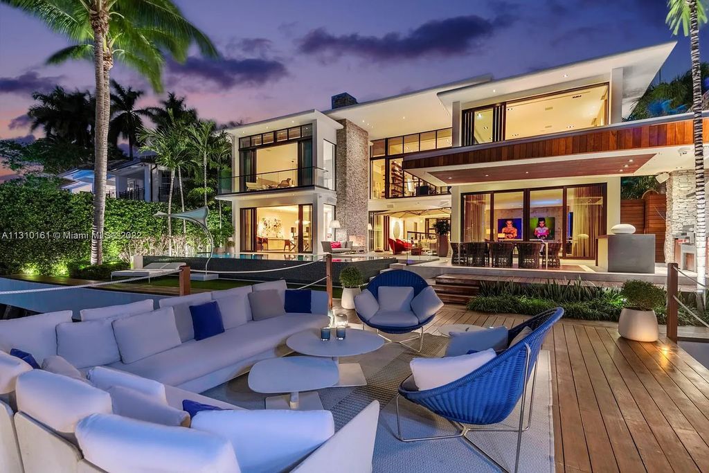 This stunning Venetian Island waterfront home located 420 W Rivo Alto Dr, Miami Beach, FL, boasts luxurious finishes. The tropical modern residence showcases a series of architectural scenes with seamless indoor-outdoor living, incorporating natural elements and offering breathtaking wide bay westerly sunsets