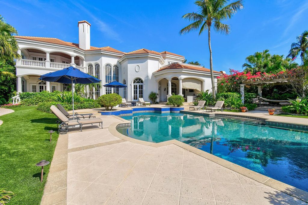 Outstanding custom estate located at 456 Mariner Dr, Jupiter, Florida, in the exclusive guard-gated community of Admirals Cove. It sits on 110' of waterfrontage with no fixed bridges. This timeless masterpiece features 5 BR/5.1 BA + an office, boasting 9,101 sq ft with soaring ceilings and spectacular water views from almost every room.