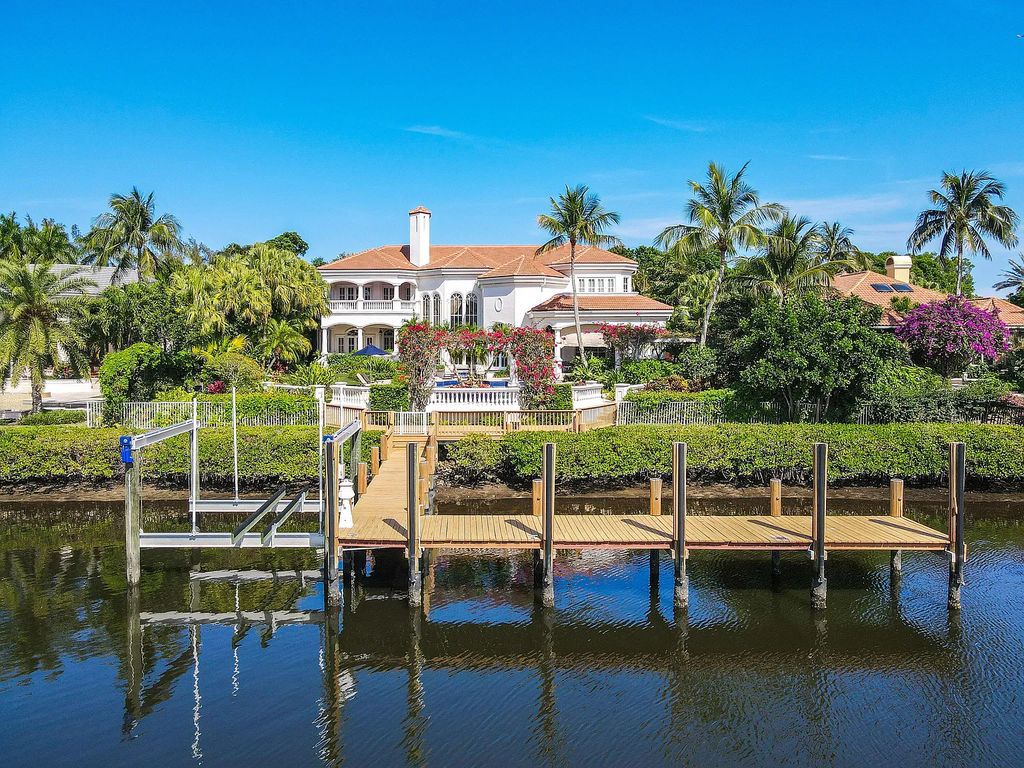 Outstanding custom estate located at 456 Mariner Dr, Jupiter, Florida, in the exclusive guard-gated community of Admirals Cove. It sits on 110' of waterfrontage with no fixed bridges. This timeless masterpiece features 5 BR/5.1 BA + an office, boasting 9,101 sq ft with soaring ceilings and spectacular water views from almost every room.