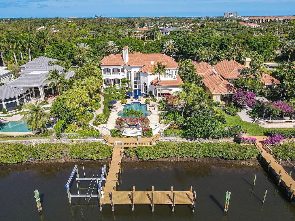 Outstanding custom estate located at 456 Mariner Dr, Jupiter, Florida, in the exclusive guard-gated community of Admirals Cove. It sits on 110' of waterfrontage with no fixed bridges. This timeless masterpiece features 5 BR/5.1 BA + an office, boasting 9,101 sq ft with soaring ceilings and spectacular water views from almost every room.