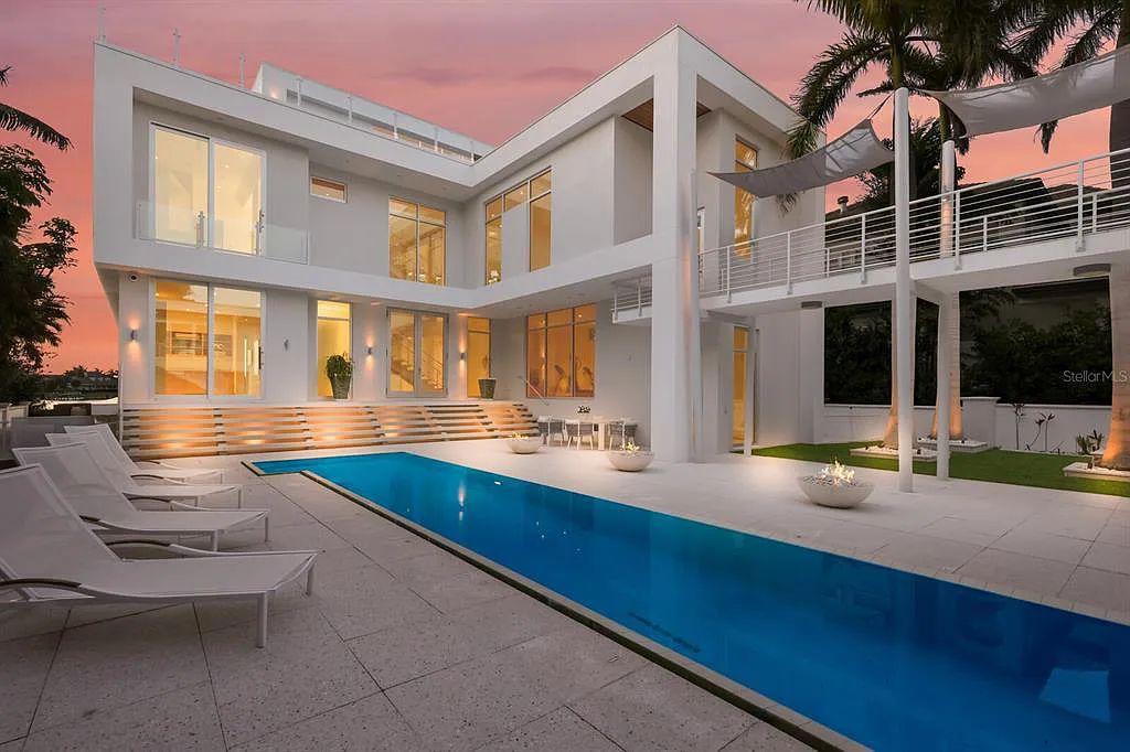 1325 Westway Dr, Sarasota, FL - A modern marvel overlooking New Pass in Lido Shores! Step into this tropical escape through the hidden courtyard that connects the three-bedroom main home to the secluded, two-bedroom guest house. The property features an expansive sundeck, a 60-foot wet-edge lap pool lined with royal palms and adorned with unique fire bowls. This serves as the perfect introduction to a contemporary masterpiece designed by DSDG Architect Mark Sultana and built by Voigt Brothers Construction.