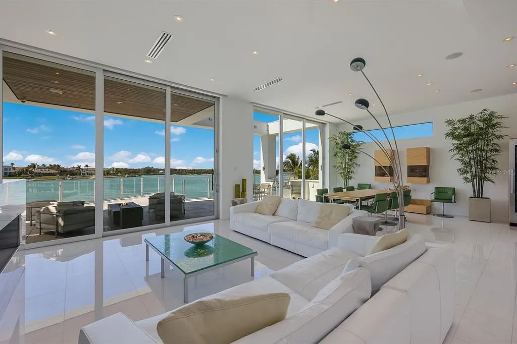 1325 Westway Dr, Sarasota, FL - A modern marvel overlooking New Pass in Lido Shores! Step into this tropical escape through the hidden courtyard that connects the three-bedroom main home to the secluded, two-bedroom guest house. The property features an expansive sundeck, a 60-foot wet-edge lap pool lined with royal palms and adorned with unique fire bowls. This serves as the perfect introduction to a contemporary masterpiece designed by DSDG Architect Mark Sultana and built by Voigt Brothers Construction.