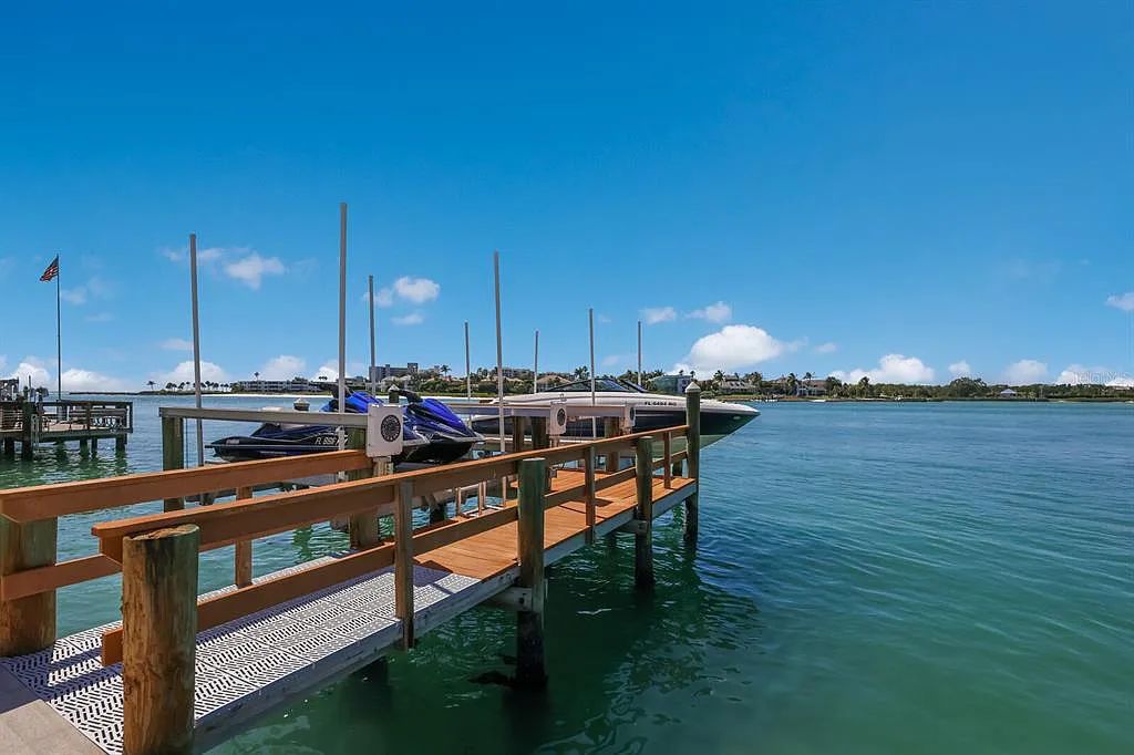 1325 Westway Dr, Sarasota, FL - A modern marvel overlooking New Pass in Lido Shores! Step into this tropical escape through the hidden courtyard that connects the three-bedroom main home to the secluded, two-bedroom guest house. The property features an expansive sundeck, a 60-foot wet-edge lap pool lined with royal palms and adorned with unique fire bowls. This serves as the perfect introduction to a contemporary masterpiece designed by DSDG Architect Mark Sultana and built by Voigt Brothers Construction.