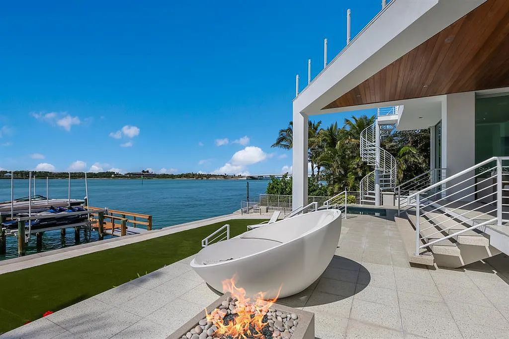 1325 Westway Dr, Sarasota, FL - A modern marvel overlooking New Pass in Lido Shores! Step into this tropical escape through the hidden courtyard that connects the three-bedroom main home to the secluded, two-bedroom guest house. The property features an expansive sundeck, a 60-foot wet-edge lap pool lined with royal palms and adorned with unique fire bowls. This serves as the perfect introduction to a contemporary masterpiece designed by DSDG Architect Mark Sultana and built by Voigt Brothers Construction.