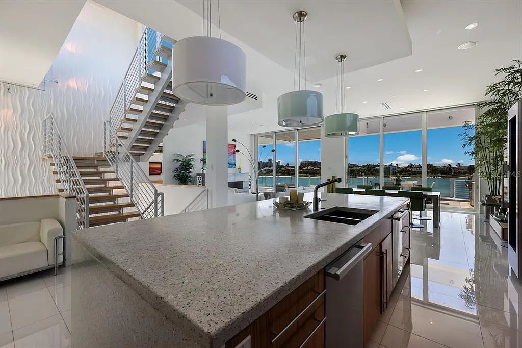 1325 Westway Dr, Sarasota, FL - A modern marvel overlooking New Pass in Lido Shores! Step into this tropical escape through the hidden courtyard that connects the three-bedroom main home to the secluded, two-bedroom guest house. The property features an expansive sundeck, a 60-foot wet-edge lap pool lined with royal palms and adorned with unique fire bowls. This serves as the perfect introduction to a contemporary masterpiece designed by DSDG Architect Mark Sultana and built by Voigt Brothers Construction.