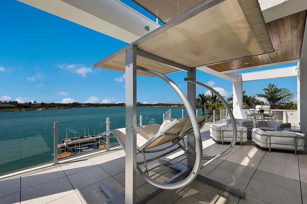 1325 Westway Dr, Sarasota, FL - A modern marvel overlooking New Pass in Lido Shores! Step into this tropical escape through the hidden courtyard that connects the three-bedroom main home to the secluded, two-bedroom guest house. The property features an expansive sundeck, a 60-foot wet-edge lap pool lined with royal palms and adorned with unique fire bowls. This serves as the perfect introduction to a contemporary masterpiece designed by DSDG Architect Mark Sultana and built by Voigt Brothers Construction.