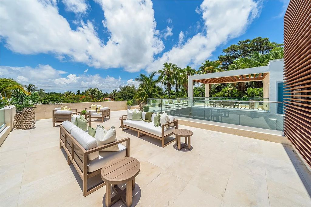 5785 Pine Tree Drive, Miami Beach, Florida, is a new Neo-Classic, one-of-a-kind, three-story waterfront home. It is fully furnished, equipped, and adorned by Argent Design. The house features an open atrium entry with water features and glass, as well as a stunning circular glass centerpiece staircase that stands 30 feet tall with a curved handrail. The living area spans an impressive 15,000 square feet, offering eight bedrooms, six full bathrooms, and two half bathrooms. The kitchen boasts large touch sensor cabinets.