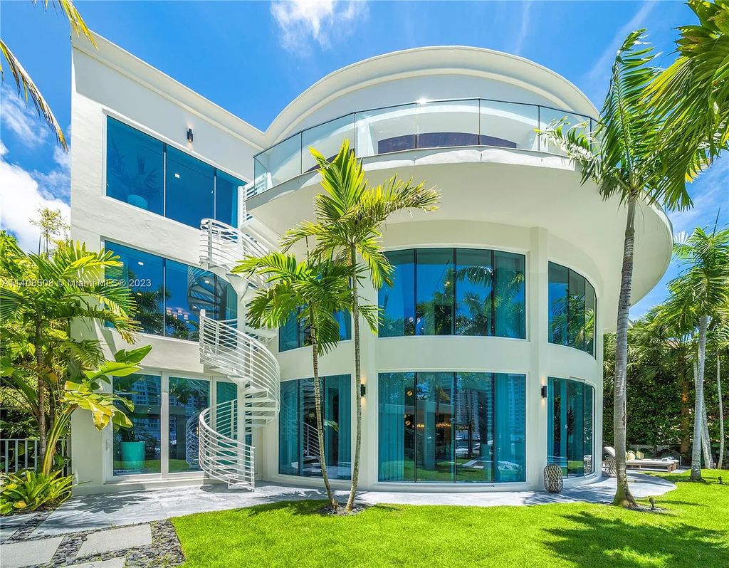 5785 Pine Tree Drive, Miami Beach, Florida, is a new Neo-Classic, one-of-a-kind, three-story waterfront home. It is fully furnished, equipped, and adorned by Argent Design. The house features an open atrium entry with water features and glass, as well as a stunning circular glass centerpiece staircase that stands 30 feet tall with a curved handrail. The living area spans an impressive 15,000 square feet, offering eight bedrooms, six full bathrooms, and two half bathrooms. The kitchen boasts large touch sensor cabinets.