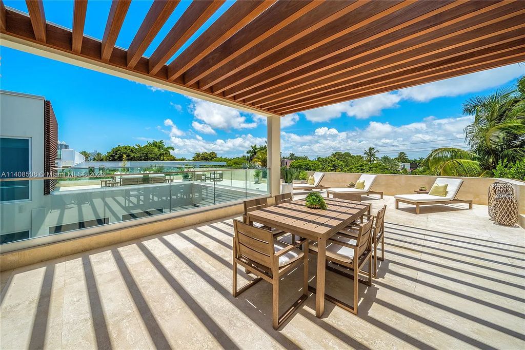 5785 Pine Tree Drive, Miami Beach, Florida, is a new Neo-Classic, one-of-a-kind, three-story waterfront home. It is fully furnished, equipped, and adorned by Argent Design. The house features an open atrium entry with water features and glass, as well as a stunning circular glass centerpiece staircase that stands 30 feet tall with a curved handrail. The living area spans an impressive 15,000 square feet, offering eight bedrooms, six full bathrooms, and two half bathrooms. The kitchen boasts large touch sensor cabinets.