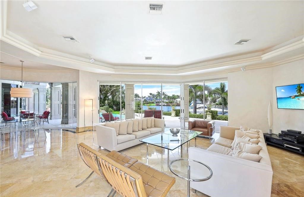 1030 Galleon Drive, Naples, Florida. An impressive and beautiful custom home sits on an oversized lot, boasting 0.8 acres which equals one and a half Port Royal lots. With over 160 feet of water frontage, this luxury residence is situated on Galleon Drive, in one of the most sought-after locations in Naples, FL. This exquisite home features five bedrooms, seven bathrooms, an office/den, a sauna, an elevator, and multiple balconies on the second floor, offering breathtaking water and sunset views. It provides a high level of privacy, making it truly exceptional.