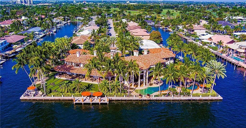 Located at 2900 NE 37th St, Fort Lauderdale, Florida, this gated palatial Palm Beach-inspired point estate is situated in the prestigious Coral Ridge Country Club enclave, spanning over 1.09 acres (+/-) and surrounded by three astonishing sides of wrap-around waterfront, amounting to an impressive 665 feet (+/-) of full-service mega-yacht dockage.