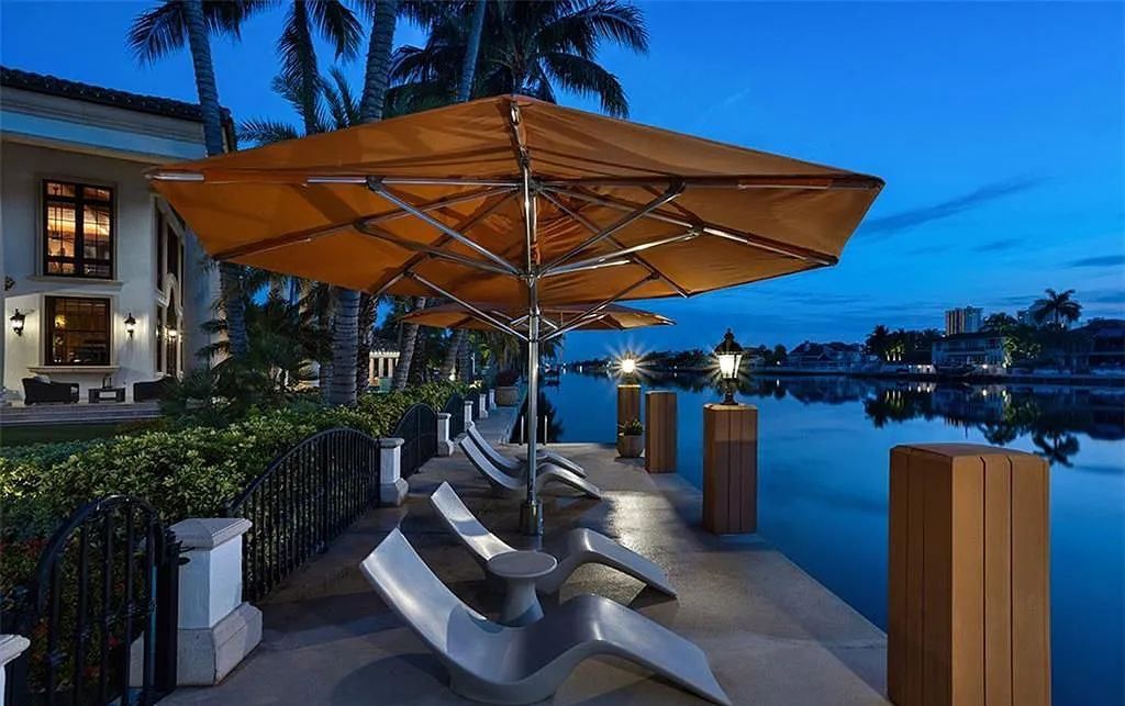 Located at 2900 NE 37th St, Fort Lauderdale, Florida, this gated palatial Palm Beach-inspired point estate is situated in the prestigious Coral Ridge Country Club enclave, spanning over 1.09 acres (+/-) and surrounded by three astonishing sides of wrap-around waterfront, amounting to an impressive 665 feet (+/-) of full-service mega-yacht dockage.