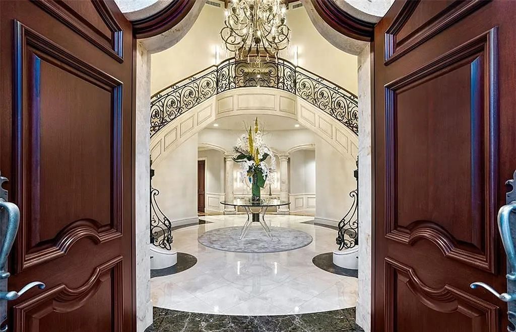 Located at 2900 NE 37th St, Fort Lauderdale, Florida, this gated palatial Palm Beach-inspired point estate is situated in the prestigious Coral Ridge Country Club enclave, spanning over 1.09 acres (+/-) and surrounded by three astonishing sides of wrap-around waterfront, amounting to an impressive 665 feet (+/-) of full-service mega-yacht dockage.