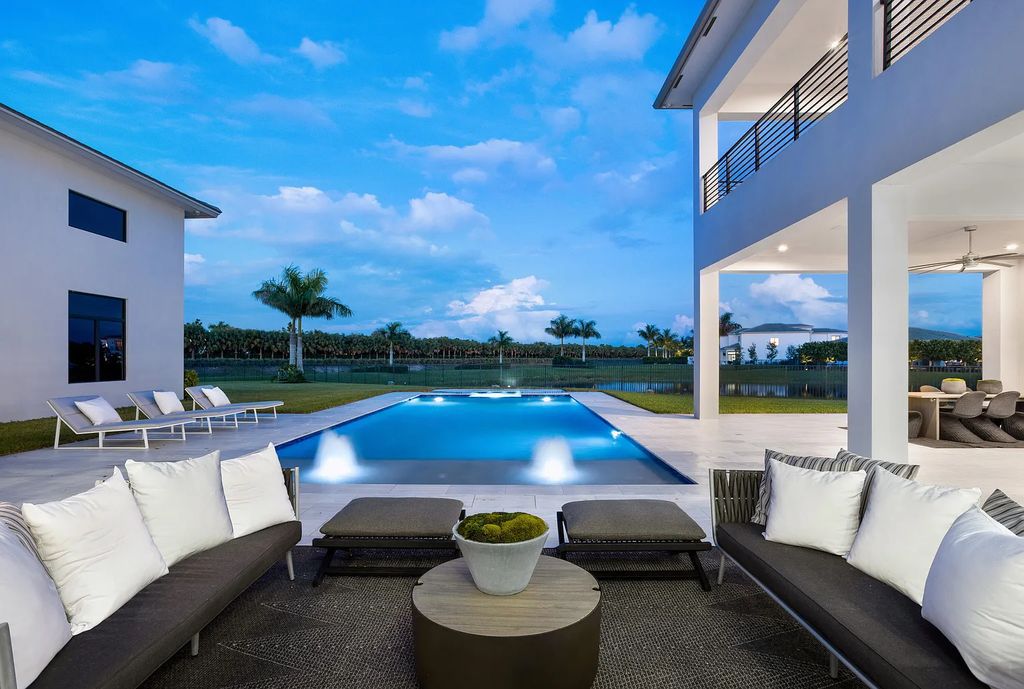 17055 Brulee Breeze Way, Boca Raton, Florida Quietly tucked away in a private cul-de-sac and nestled on an oversized 0.72 +- acre lot, this coveted Vanderbilt Grand Contemporary model spans 11,873 +- square feet of exquisite living. Featuring six commodious bedrooms, eight full and two partial bathrooms, four car garage, custom and upgraded accents, and luxuriant outdoor living space, this sprawling pristine lakefront estate was constructed by the prestigious GL Homes in 2020 and is the largest model offered at Boca Bridges.