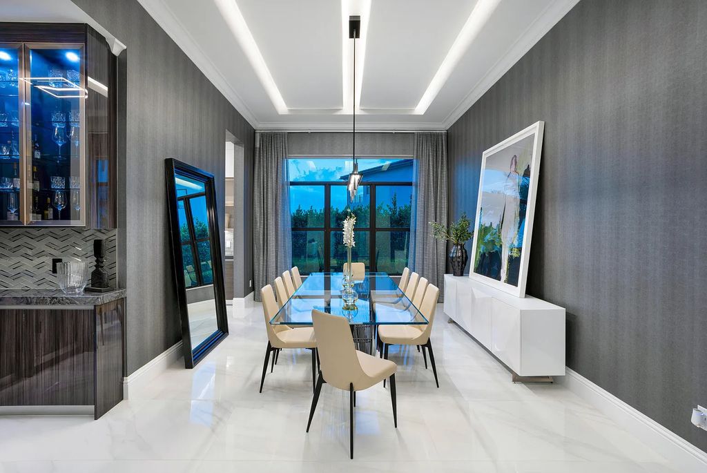 17055 Brulee Breeze Way, Boca Raton, Florida Quietly tucked away in a private cul-de-sac and nestled on an oversized 0.72 +- acre lot, this coveted Vanderbilt Grand Contemporary model spans 11,873 +- square feet of exquisite living. Featuring six commodious bedrooms, eight full and two partial bathrooms, four car garage, custom and upgraded accents, and luxuriant outdoor living space, this sprawling pristine lakefront estate was constructed by the prestigious GL Homes in 2020 and is the largest model offered at Boca Bridges.