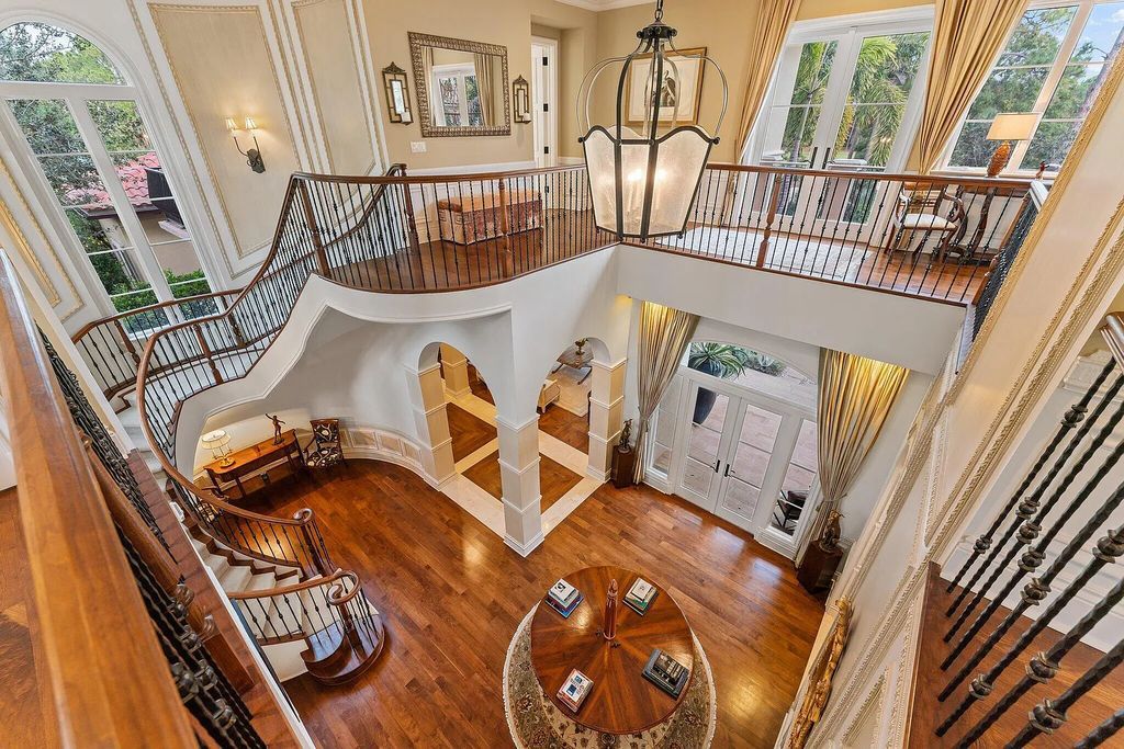 The home features a gracious two-story entry with a grand sweeping staircase, high ceilings throughout, a spacious primary suite with dual luxury baths and sitting room, a nice family space with a game room, bar, wine room, chef's kitchen, and family room with extended outdoor living.