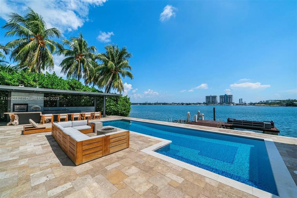 This magnificent waterfront property in Miami Beach, FL offers 90 feet of pristine water frontage, breathtaking views, and direct access to the beautiful waterways of Miami. The home features an open floor plan, a new summer kitchen with a Brazilian-style BBQ and pizza oven, gas fireplaces poolside and dockside, a custom 4-car garage, and more.