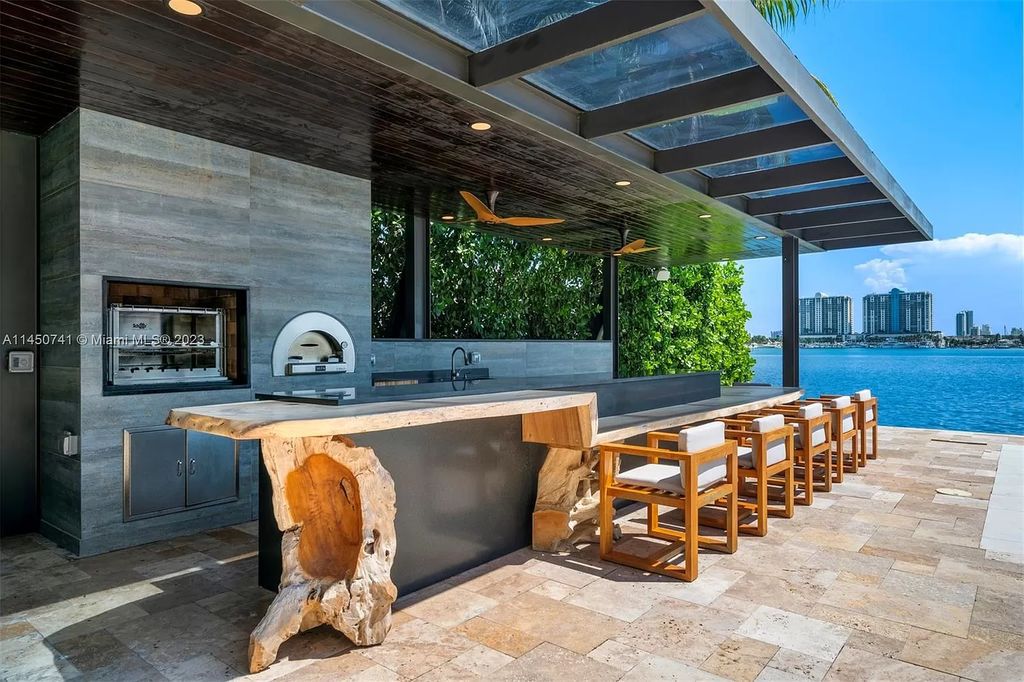 This magnificent waterfront property in Miami Beach, FL offers 90 feet of pristine water frontage, breathtaking views, and direct access to the beautiful waterways of Miami. The home features an open floor plan, a new summer kitchen with a Brazilian-style BBQ and pizza oven, gas fireplaces poolside and dockside, a custom 4-car garage, and more.