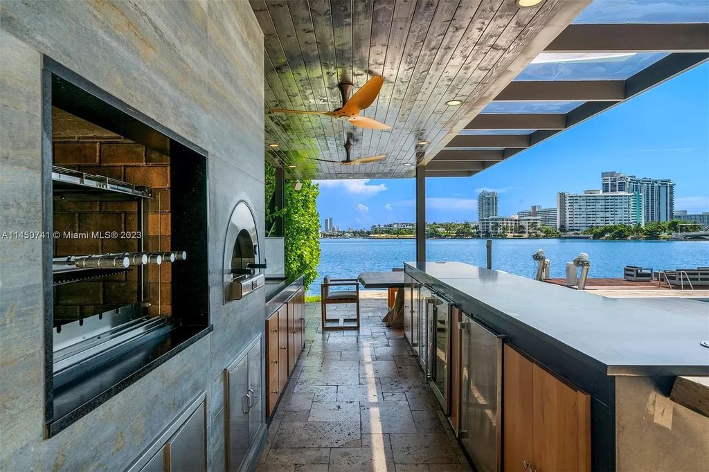 This magnificent waterfront property in Miami Beach, FL offers 90 feet of pristine water frontage, breathtaking views, and direct access to the beautiful waterways of Miami. The home features an open floor plan, a new summer kitchen with a Brazilian-style BBQ and pizza oven, gas fireplaces poolside and dockside, a custom 4-car garage, and more.