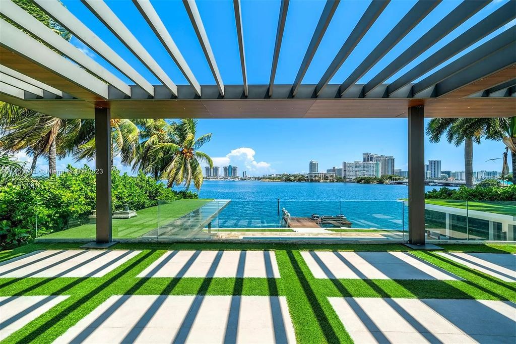 This magnificent waterfront property in Miami Beach, FL offers 90 feet of pristine water frontage, breathtaking views, and direct access to the beautiful waterways of Miami. The home features an open floor plan, a new summer kitchen with a Brazilian-style BBQ and pizza oven, gas fireplaces poolside and dockside, a custom 4-car garage, and more.