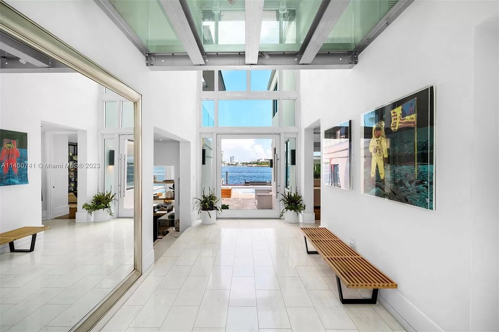 This magnificent waterfront property in Miami Beach, FL offers 90 feet of pristine water frontage, breathtaking views, and direct access to the beautiful waterways of Miami. The home features an open floor plan, a new summer kitchen with a Brazilian-style BBQ and pizza oven, gas fireplaces poolside and dockside, a custom 4-car garage, and more.