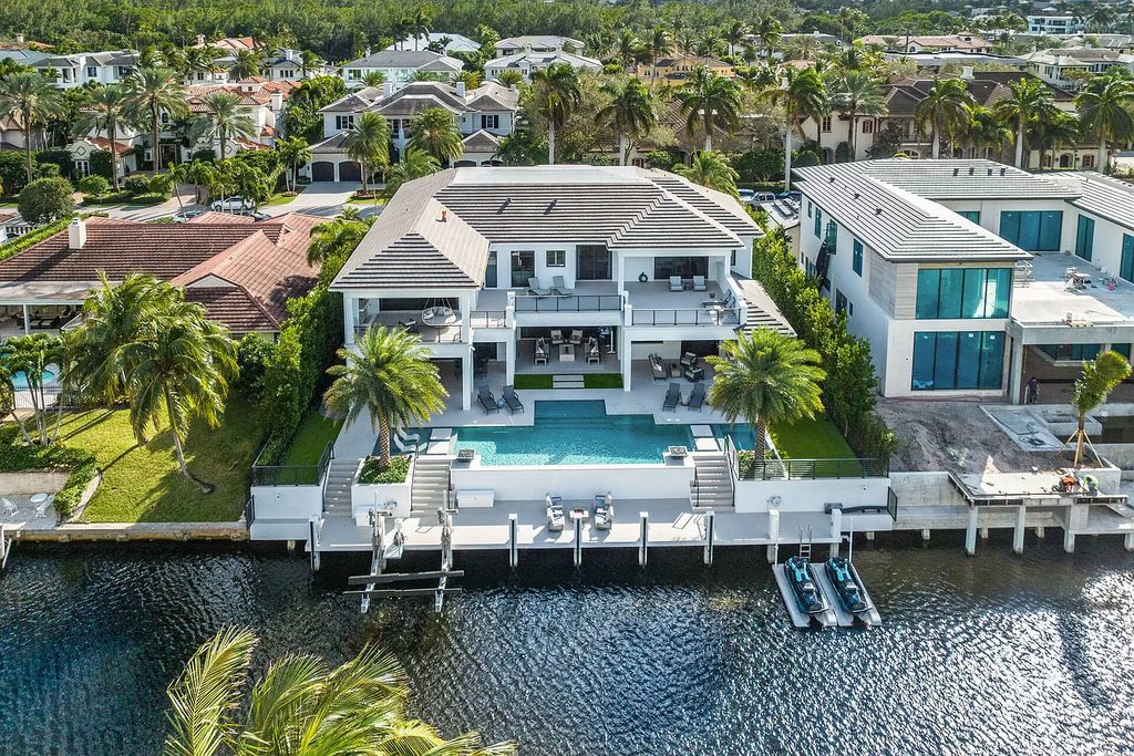 Set sail from your backyard in this custom 5-bedroom waterfront estate by SRD Building Corp. Luxurious living awaits with resort-style pool, dock, chef's kitchen, & smart home features. Explore 215 W Coconut Palm Rd, Boca Raton.