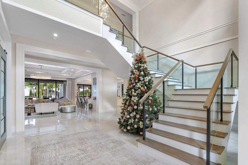 Set sail from your backyard in this custom 5-bedroom waterfront estate by SRD Building Corp. Luxurious living awaits with resort-style pool, dock, chef's kitchen, & smart home features. Explore 215 W Coconut Palm Rd, Boca Raton.