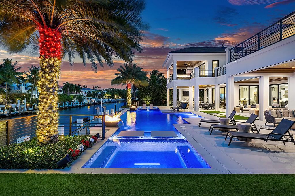 Set sail from your backyard in this custom 5-bedroom waterfront estate by SRD Building Corp. Luxurious living awaits with resort-style pool, dock, chef's kitchen, & smart home features. Explore 215 W Coconut Palm Rd, Boca Raton.