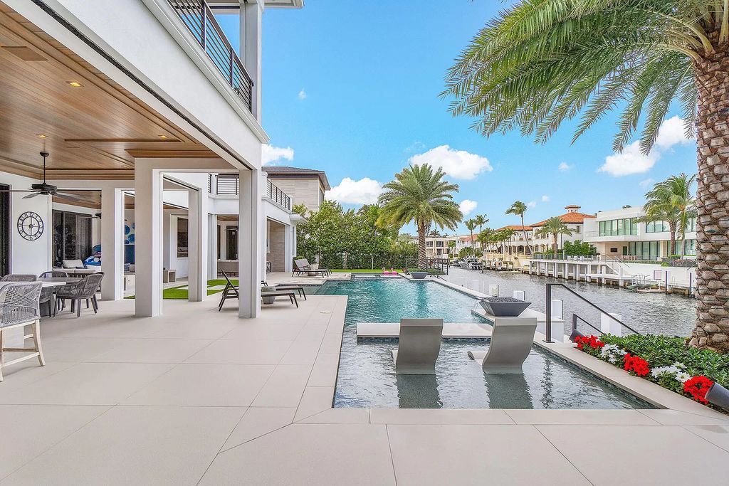 Set sail from your backyard in this custom 5-bedroom waterfront estate by SRD Building Corp. Luxurious living awaits with resort-style pool, dock, chef's kitchen, & smart home features. Explore 215 W Coconut Palm Rd, Boca Raton.