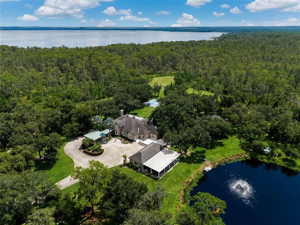 Escape to your own 54-acre playground! Fully furnished, income-generating Clermont Chain lakefront estate boasts 12 bedrooms, 3 kitchens, game rooms, arcade, pool and endless lake activities.