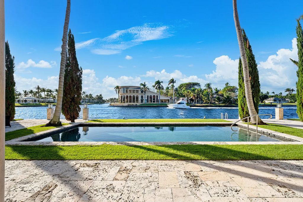 Gated Boca Raton estate with breathtaking Intracoastal and Royal Palm Grand Canal views. Tropical Georgian design with grand living spaces, gourmet kitchen, luxurious primary suite and resort-style pool/patio.