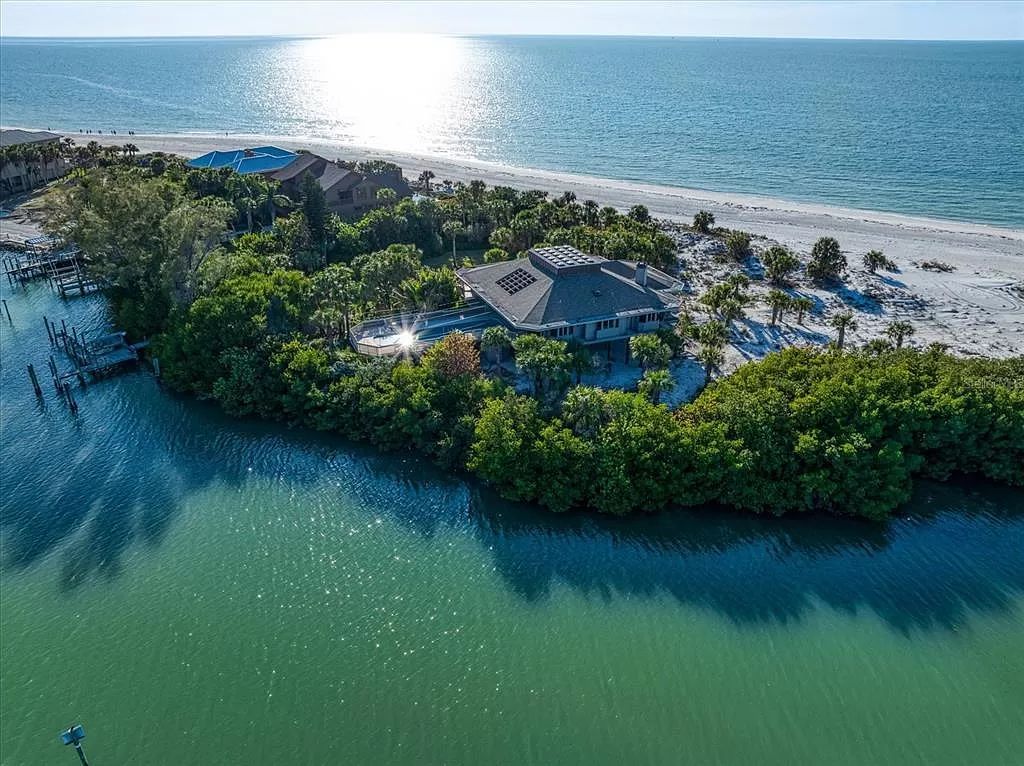 Find serenity on this pristine Florida estate. Enjoy miles of private beach, protected dockage, stunning views, and an elevated home with a unique indoor pool.