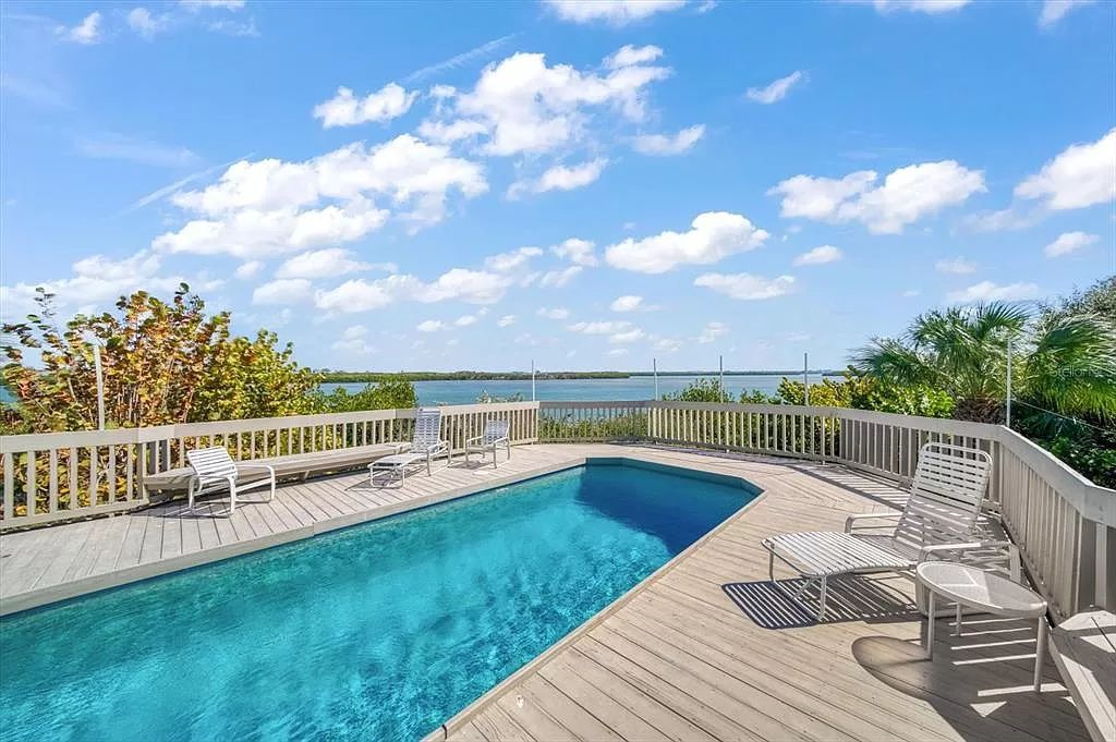 Find serenity on this pristine Florida estate. Enjoy miles of private beach, protected dockage, stunning views, and an elevated home with a unique indoor pool.