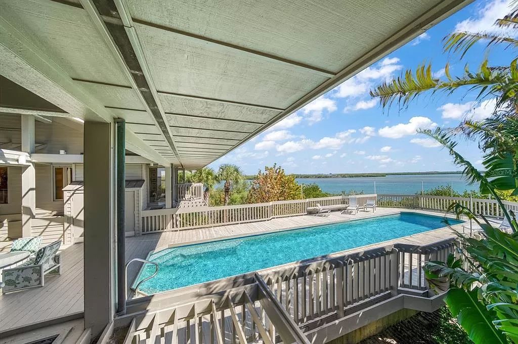 Find serenity on this pristine Florida estate. Enjoy miles of private beach, protected dockage, stunning views, and an elevated home with a unique indoor pool.