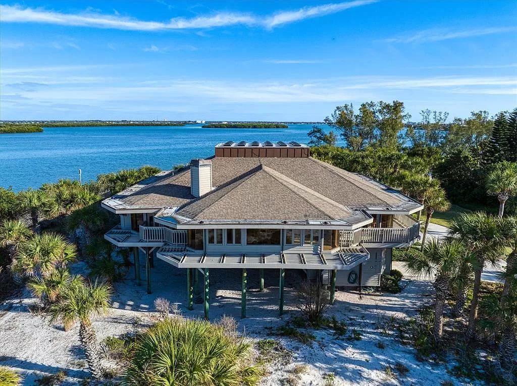 Find serenity on this pristine Florida estate. Enjoy miles of private beach, protected dockage, stunning views, and an elevated home with a unique indoor pool.