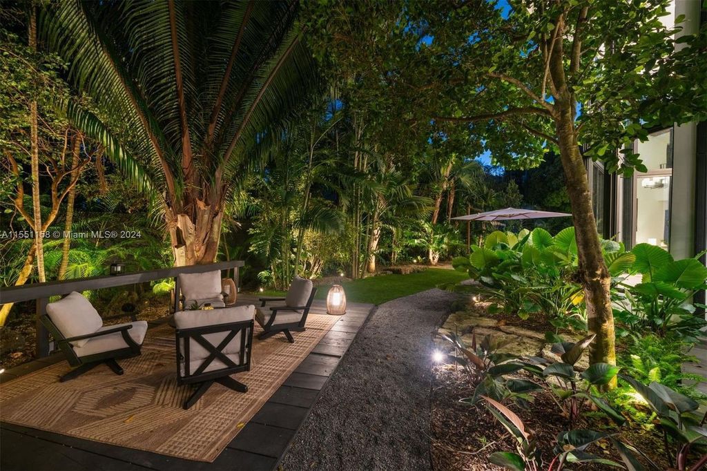 Experience ultimate privacy in this stunning 7,599 SF estate. Completely renovated in 2022, it boasts light-filled living spaces, a gourmet kitchen, a heated pool, and lush grounds in sought-after South Coconut Grove.