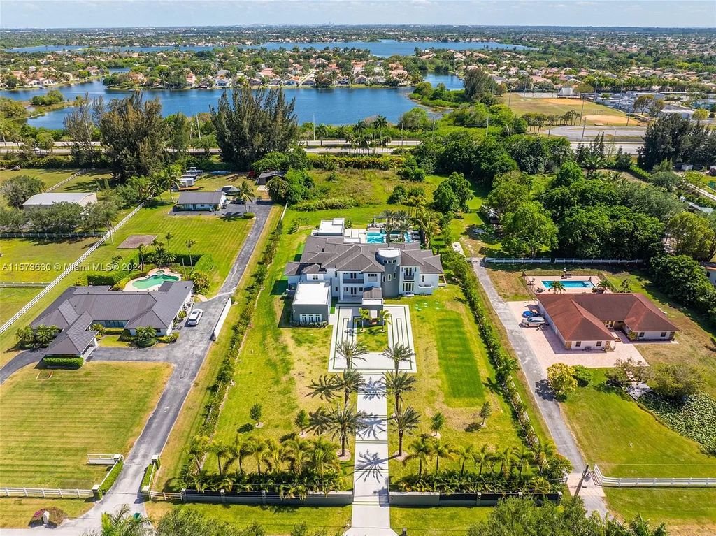 Live like royalty in this sprawling 2.25-acre Southwest Ranches estate. This 12,000+ sq ft mansion boasts resort-style amenities, a sunken entertainment area, movie theatre car showroom, and a hidden office. Experience unparalleled luxury!