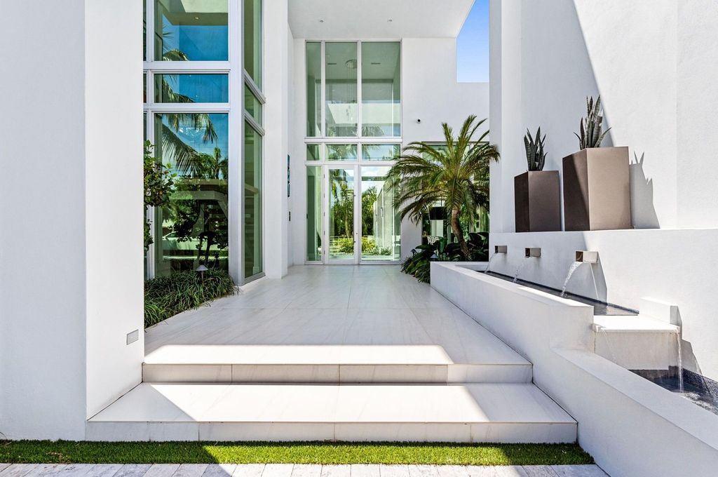 This 5-bedroom mansion in Boca Raton's Estate Section seamlessly blends indoor - outdoor living with designer finishes, resort-style pool, and lush landscaping. Designed by famed architect George Brewer, this masterpiece offers privacy and luxury in a prestigious location.