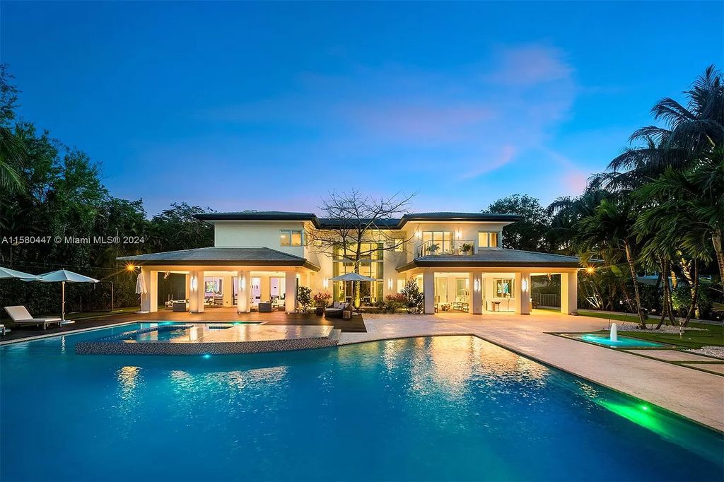 Enter a world of luxury in this exquisite 2-story gated sanctuary. Boasting a grand foyer, chef's kitchen, 4-suite bedrooms, elevator, home theater, and tropical backyard oasis with a guest house, this home offers unparalleled living.