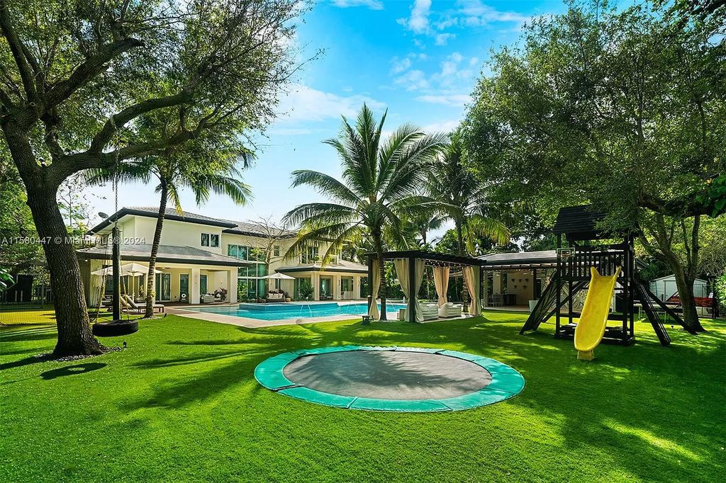 Enter a world of luxury in this exquisite 2-story gated sanctuary. Boasting a grand foyer, chef's kitchen, 4-suite bedrooms, elevator, home theater, and tropical backyard oasis with a guest house, this home offers unparalleled living.