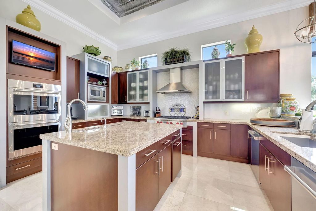 Discover unparalleled luxury in this meticulously crafted Boca Raton estate. This showcase former model home boasts a saltwater pool, spa, state-of-the-art movie theatre, wine cellar, and resort-style amenities. Experience ultimate privacy in a prestigious gated community next to a nature preserve.