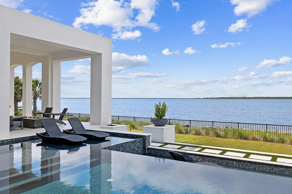 This extraordinary 7,587 square feet residence boasts 6 spacious bedrooms, 7 custom bathrooms, an infinity pool with swim-up bar, a coveted 70' private boat slip, and breathtaking bay views.